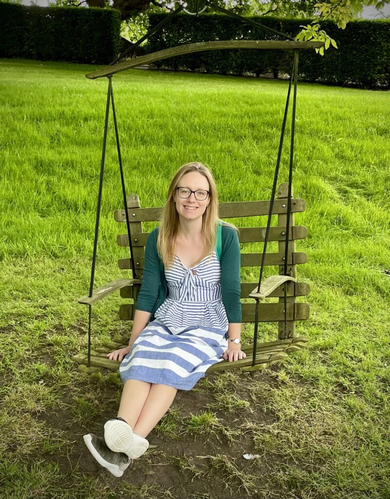 Photo of a lady sitting on a swing in the garden 