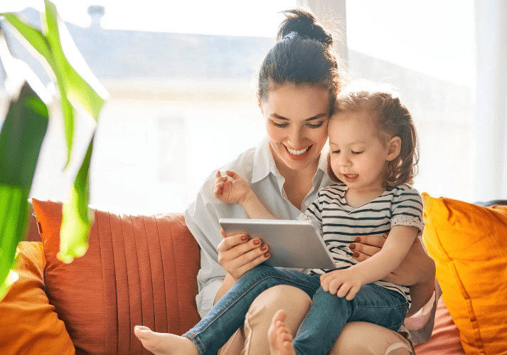 women with child on her lap holding a ipad